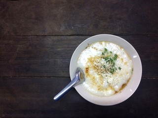 Pork congee, add egg, garnished with sauce and vegetables