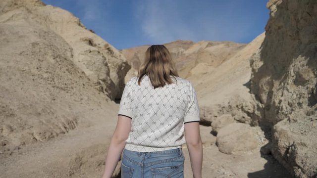 Woman walking in dry desert canyon exploring Death Valley Travel and adventure