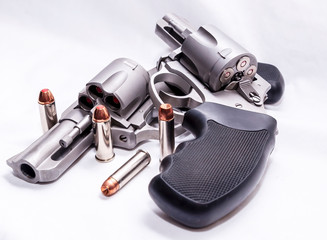 Two revolvers, a 357 magnum and a 44spl loaded with hollow point bullets on a white background with bullets for each gun next to them