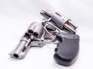 Two revolvers, a 357 magnum and a 44spl loaded with hollow point bullets on a white background