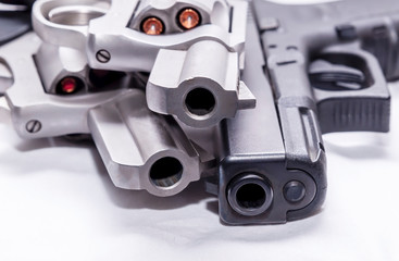 Two revolvers, a 357 magnum and a 44spl loaded with hollow point bullets on a white background with bullets for each gun next to them