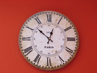 antiguo reloj sobre pared roja
