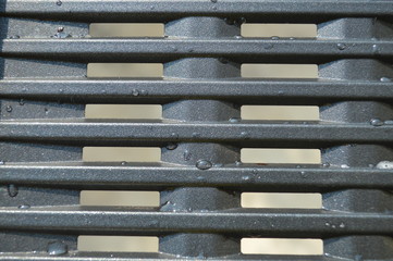 The abstract of the surface of a metal grill used to grill the meat