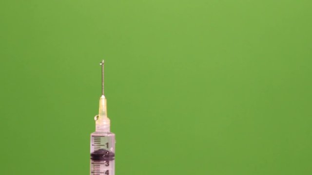 Needle squirts twice in the air on green screen background.