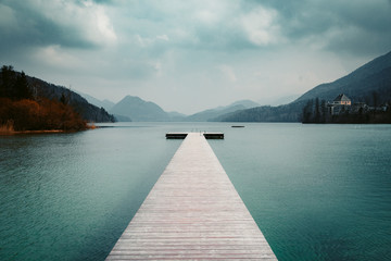 Wooden landing stage with alpine lake in summer