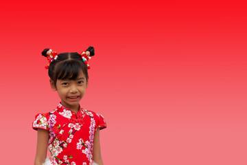 Happy chinese new year. Little girl stand pose and smiled brightly isolated on red background.  