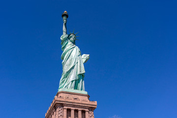 Fototapeta premium The Statue of Liberty under the blue sky background, Lower Manhattan, New York City, Architecture and building with tourist concept