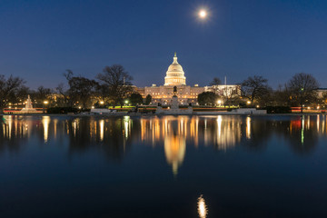 United States Capitol Building at twilight time with super full moon reflection with the big pool, Washington, DC, United States of America or USA, history and culture for travel concept