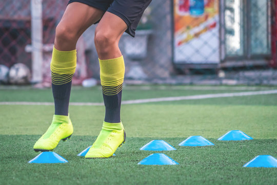Soccer player feet is training with marker in soccer academy field
