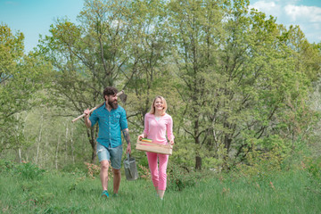 Obraz premium Two people walking in agricultural field. Earth day. A pair of farms working in the garden. Couple Farmers. Wife and husband planting in the vegetable garden.
