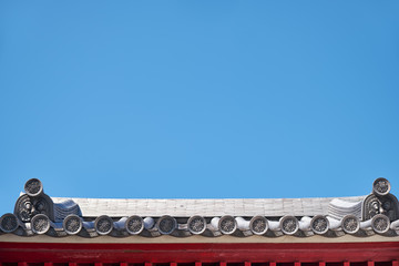 Fototapeta na wymiar The wadangs adorned with moulded designs on the roof of traditional Japanese shrine. Osaka. Japan