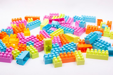 multi colored blocks of a children designer scattered on a white background