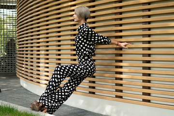 beautiful caucasian model in black suit with white spots in high heels, pants and shirt. Long legs,...