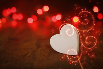 Valentines day concept. one heart over wooden background and glitter lights