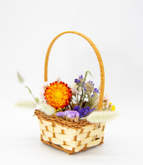 Fototapeta na wymiar Wicker basket with bright colored dried flowers