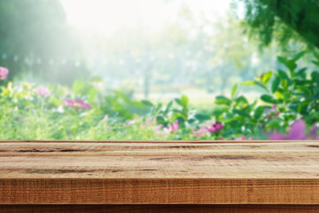 Blurred nature flower garden background and empty wooden table.