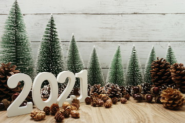 Happy New Year 2021 festive background with christmas tree and pine cone decoration on wooden...
