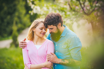 Passion and sensual touch. Couple in live walking in the spring Park and enjoying the beautiful spring blossom nature.