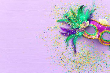 Holidays image of mardi gras masquarade venetian mask over purple background. view from above