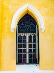Obraz premium Window Thai architecture is influenced by Europe,Yellow wall And Green door Unique pattern of Thailand,Texture wall color Stain