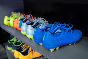 A lot of cleats , soccer boots on shoe rack prepared before football player traning or match...
