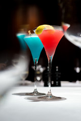 red cocktail in selective focus over the other glasses for abstract mood