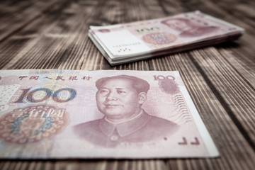 One hundred Chinese yuan on a wooden background