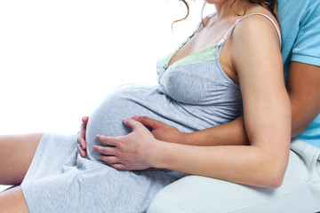 A young black man helps his white wife with birth pain with a ball. Partnered birth, partnered delivery. Isolated white background.