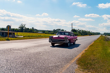 Vintage American retro car on rural road. Cuba Vinales valley