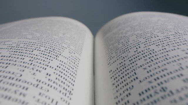 Close up shot of open novel or textbook isolated on grey background.