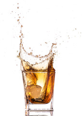 big splash from falling ice in a glass of whiskey on a white background