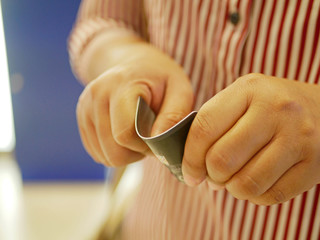 A credit card in a woman's hands being folded and destroyed - breaking free of financial bondage