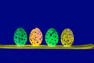 Glowing neon eggs on a blue background. Easter photo