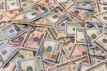 Dollar banknotes dispersed on wooden table close up