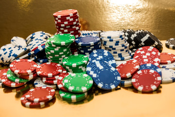 Stacks of poker chips isolated on golden background. Casino