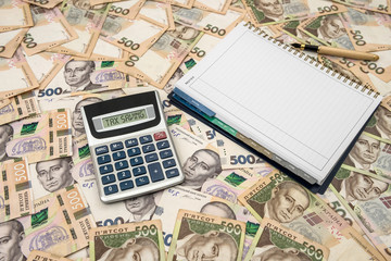 Empty notepad with calculator on Ukrainian Money backgrounds. 500 banknotes. Hryvnia (UAH). Top view