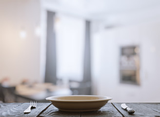 empty plate with fork and knife on wooden table