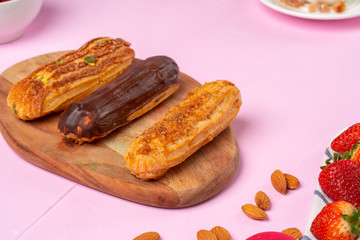 Home made cake eclairs on pink table