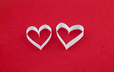 A pair of white hearts on a red felt background with an empty place for your text. Valentine's day stock photo for web, print, postcards, invitations, wallpaper and background.