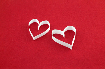 A pair of white hearts on a red felt background with an empty place for your text. Valentine's day stock photo for web, print, postcards, invitations, wallpaper and background.