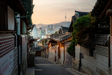 Traditional Korean style architecture at Bukchon Hanok Village with N Seoul Tower in background in Seoul, South Korea. Asian tourism, history building, or tradition culture and travel concept