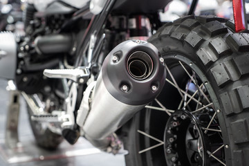 Obraz na płótnie Canvas Close-up of exhaust or Intake of black sport racing Motorcycle with new tire and wheel in showroom. Low Angle Photograph Of Motorcycle..