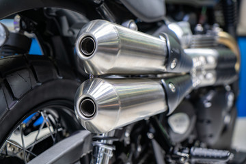 Close-up of exhaust or Intake of black sport racing Motorcycle with new tire and wheel in showroom. Low Angle Photograph Of Motorcycle..