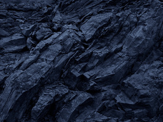 Toned mountain texture. Detail. Blue stone background. Dark blue grunge background. Deep blue rock stones background. Close-up. Abstract black background.