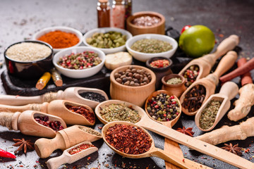 Spices and herbs over black stone background. Top view with free space for menu or recipes