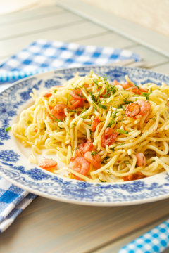 A plate of delicious italian pasta spaghetti with shrimps and herbs. Vertical image