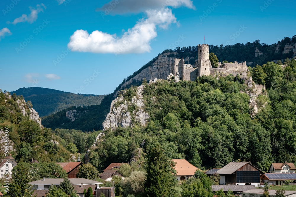 Wall mural romantic castle on top of a hill in a mountainous valley