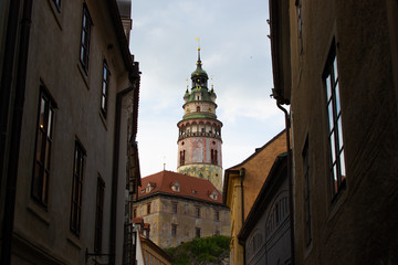 Fototapeta na wymiar Castle Tower, the most famous symbol of Cesky Krumlov, in State Castle, viewed between some buildings (Czech Republic)