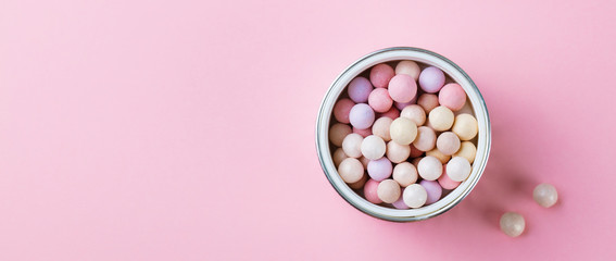Pearl make up powder on pink pastel background. Top view. Copy space.