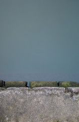 Part of the shore and the bluish water of the pond